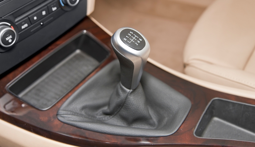 Alavanca de câmbio manual de seis marchas com coifa de couro no console do carro